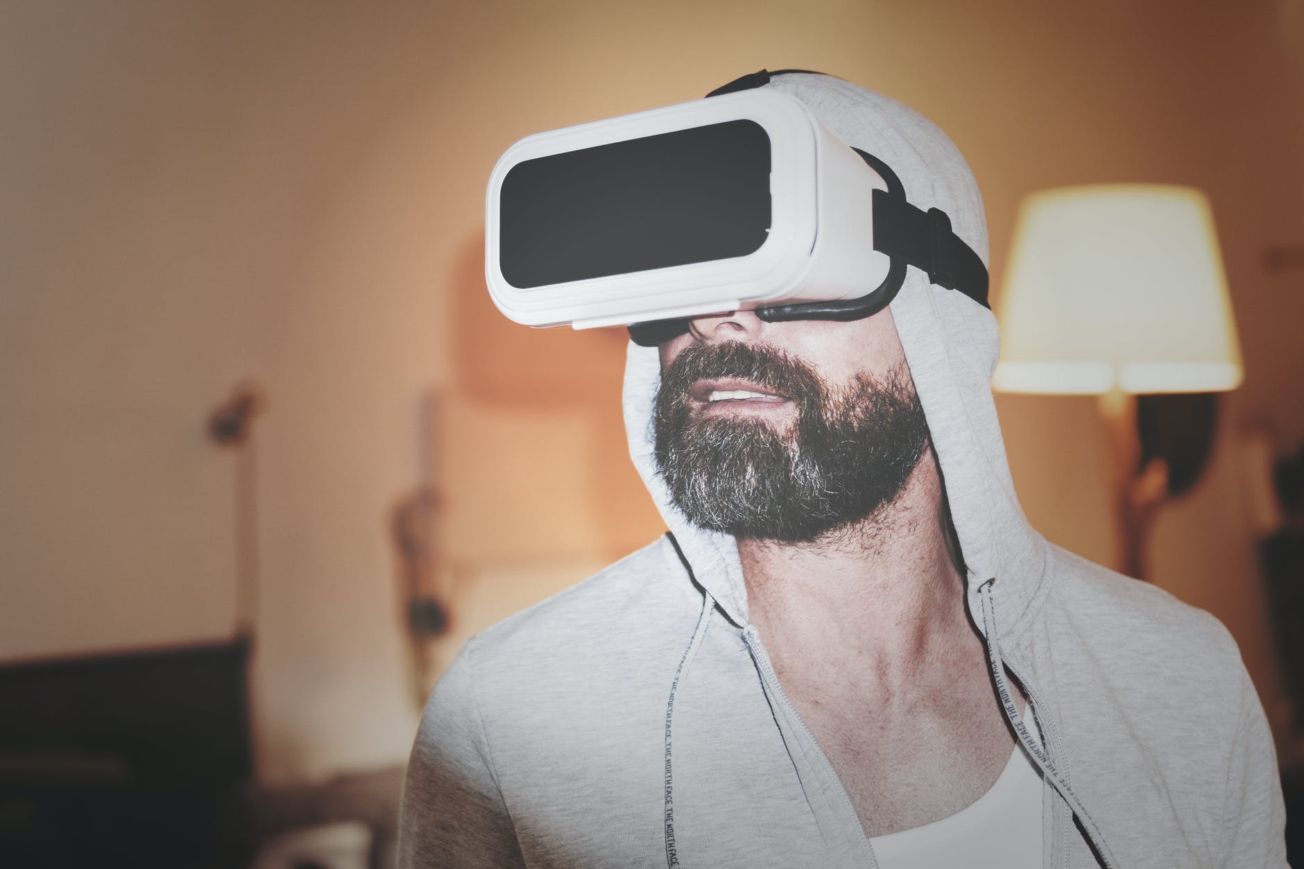 man wearing gray hoodie and white virtual reality headset