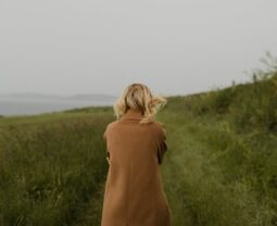 anonymous woman walking in cold field