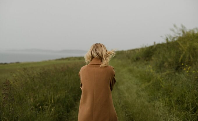 anonymous woman walking in cold field