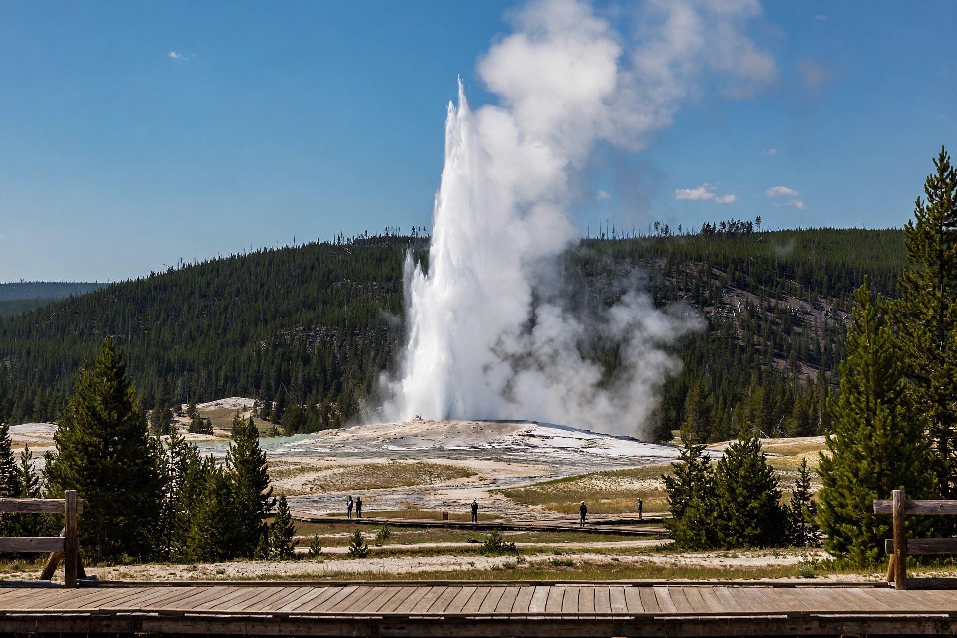 Old Faithful geyser erupting beside colourful hot springs in Yellowstone